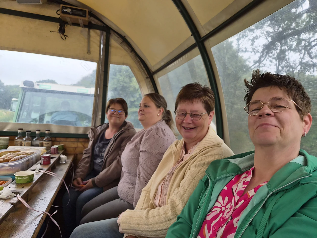 Vier Frauen im Planwagen, vorn zieht der Trecker