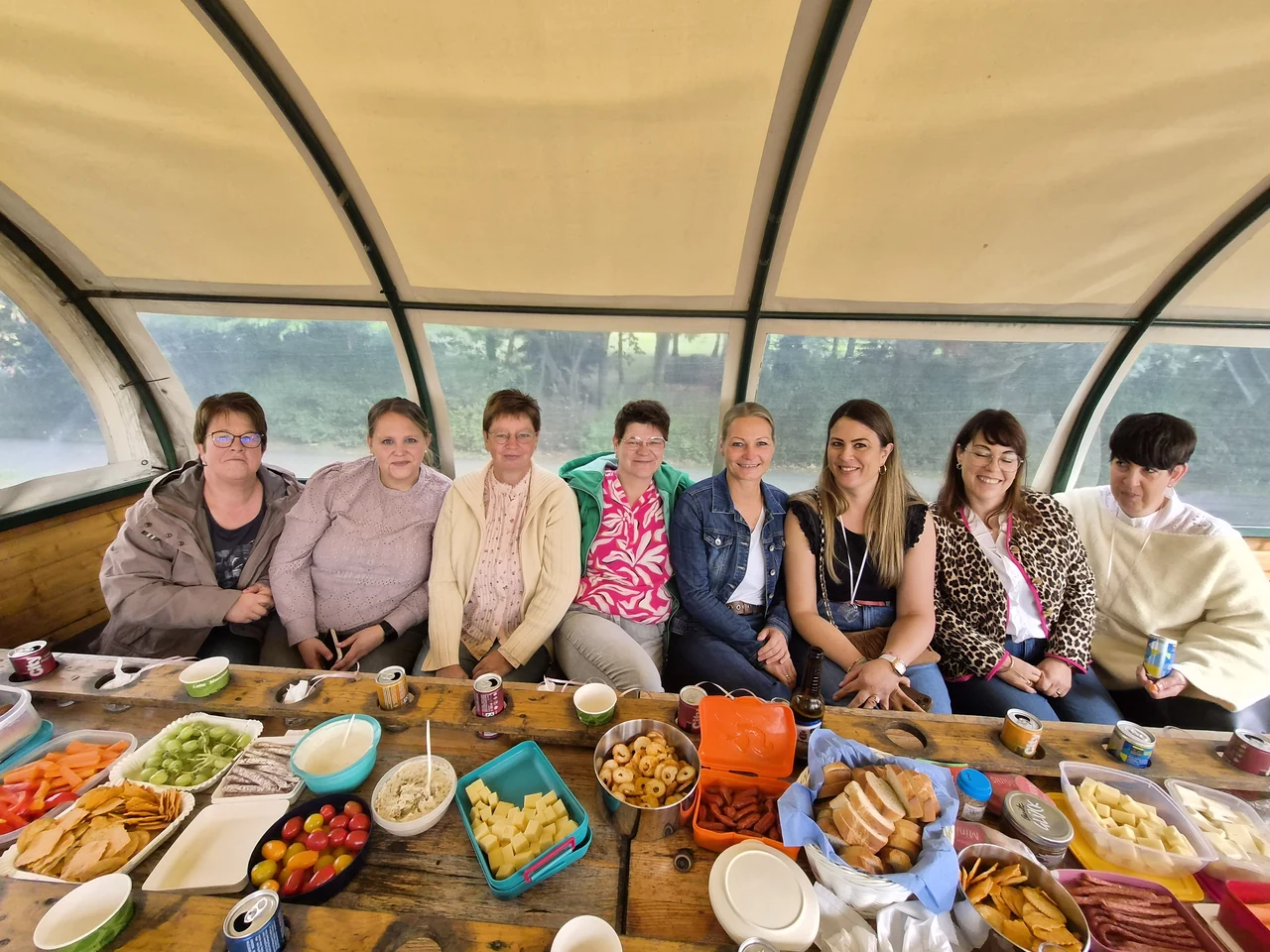 Acht auf einer Bank: Gruppenbild an der Tafel im Planwagen