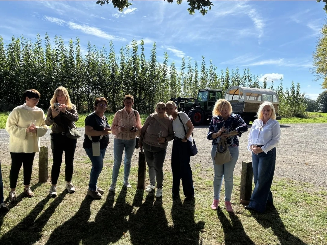 Die Gruppe vor Trecker und Planwagen im Sonnenschein