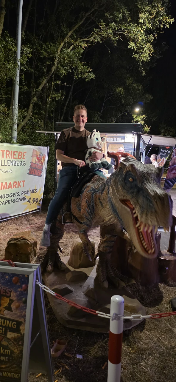 Auf dem Dinosaurier mit der Plüschkuh